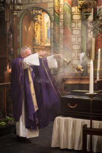 De pastor bewierookt de overledene: 'Hier op aarde werd de verzorgingsstaat niet zo vaak bewierookt. Hier doen wij dat wel.' Foto Willem Popelier. 